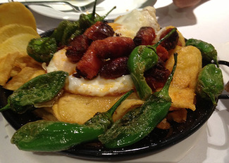 Sartén de huevos rotos con chistorra y pimientos de Padrón