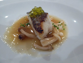 Suprema de Corvina confit con aceite de pimienta roja, infusión de jamón ibérico y setas de temporada