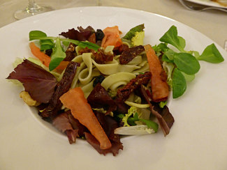 Ensalada de espinacas y pasta con pétalos de tomate y pasas 