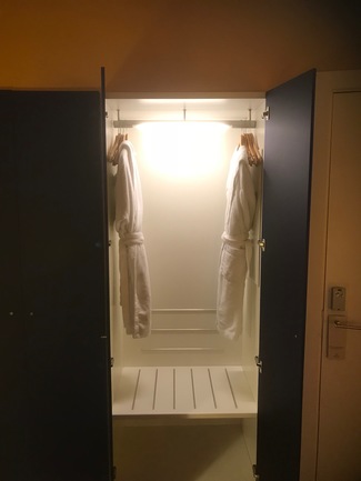 Detalle de armario iluminado con los albornoces.