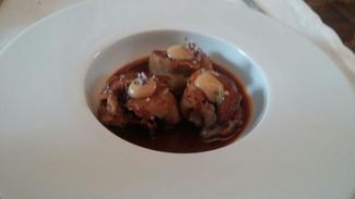 Manitas de cerdo rellenas de morcilla, manzana asada y jugo de pimientos