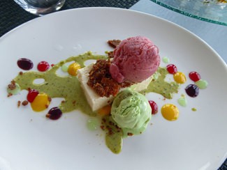 Flan de queso sobre tierra de fresas, compota de ruibarbo, gel de lima, helado de pistacho y fresas