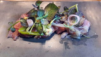 Ensalada de presa ibérica a la brasa con calçots, mostaza y berros.