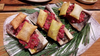 Steak tartar templado sobre tuétano a la brasa y patatas soufflés y tobiko