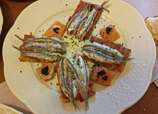 Coca anisada con samfaina, boquerones y salmón marinado.