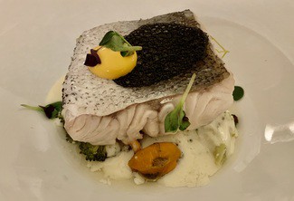 Lomo de merluza al vapor, puerro confitado y salsa de chicharros