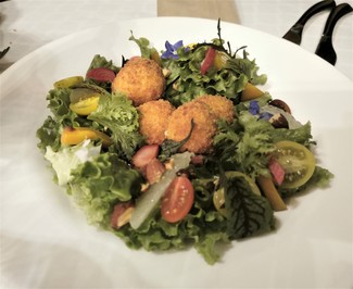 La ensalada con las croquetas de queso