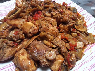 Conejo al ajillo con champiñones, pimiento rojo, albahaca y pimienta cayena al fino de Jerez.