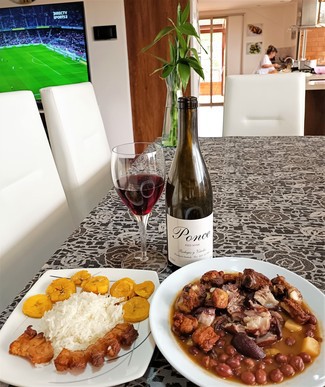 Con los frijoles con manitas, costilla, chicharrón y patacón.
