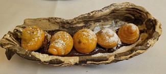 Buñuelos rellenos de trufa de chocolate sobre chocolate.