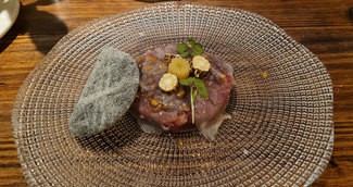 Tartar de vaca vieja con maiz, aceite de carbón y panceta.