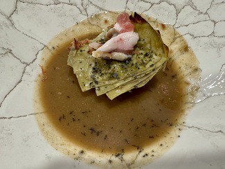 Alcachofa confitada con caldo de boletus, lámina de tocino y polvo de jamón