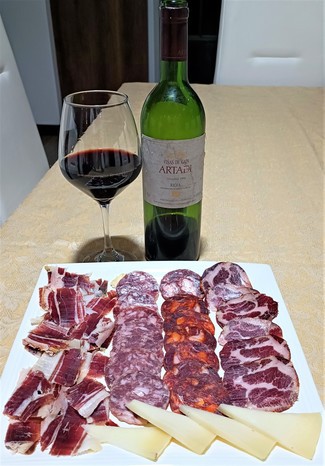 Con el surtido de jamón y embutidos ibéricos con queso curado