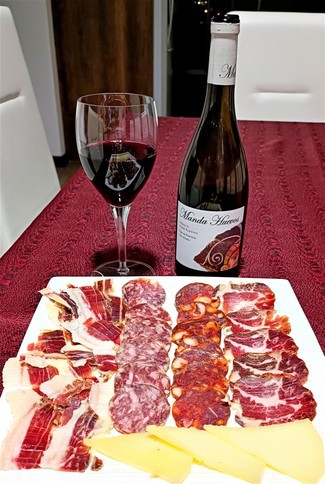 Con el surtido de jamón y embutidos ibéricos con queso curado