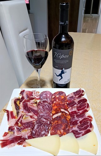 Con el surtido de jamón y embutidos ibéricos con queso curado