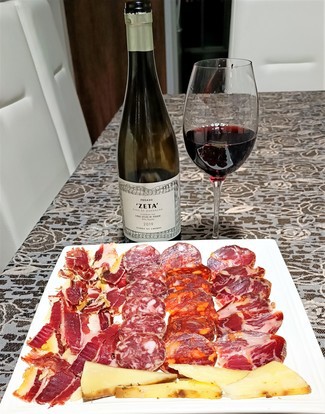 Con el surtido de jamón y embutidos ibéricos con queso curado