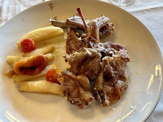 Chuletillas de lechazo con patatas fritas y pimientos.