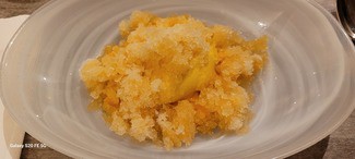 Granizado de piña sobre un lecho de mango y helado de mango.