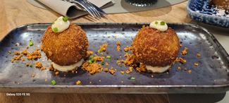 Croquetas de carne de perol y setas shiitake salteadas con ajetes tiernos y emulsión de miel de tomillo.