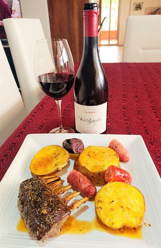 Con un rack de borrego con papas, salchichas, chorizo y morcillas al horno
