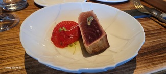 Lomo de atún con tomate confitado y aceite de hierbas.