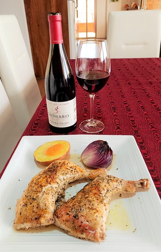 Con los muslos de pollo al horno con cebolla morada, papa y ají.