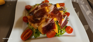 Ensalada verde con tomate, brotes, mango y jamón ibérico