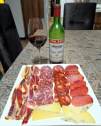 Con un surtido de queso de oveja trufado, embutidos y jamón ibéricos.