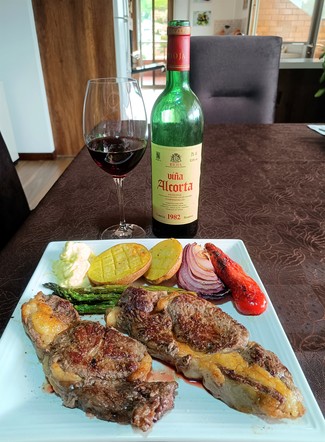 Con los Ribeyes con trigueros, papas, cebolla y pimiento al horno con all-i-oli.