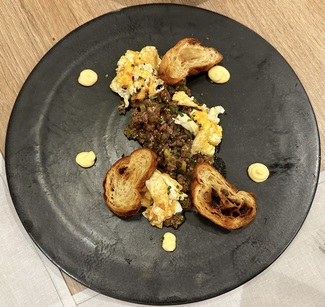 Steak tartar de buey Minhota, huevo campero frito y croissant crujiente.