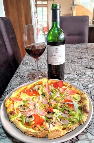 Con la pizza de prosciutto, bacon, champiñones y aceitunas.