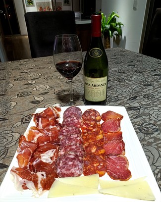 Con un surtido de queso trufado de oveja, embutidos y jamón ibéricos.