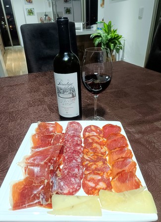 Con un surtido de queso trufado de oveja, embutidos y jamón ibéricos.