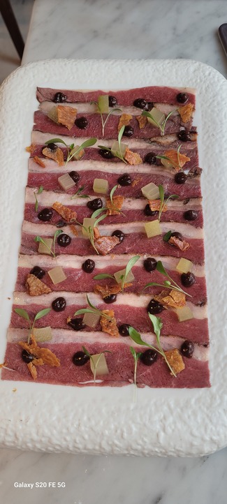 Carpaccio de magret de pato de ‘Coll Verd’ ahumado a la brasa, con salsa hoisin artesanal, dados de pepino y piel de pollo crujiente