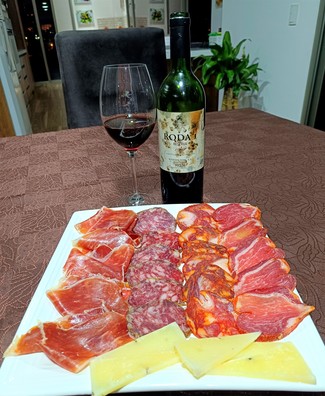 Con un surtido de queso trufado de oveja, embutidos y jamón ibéricos
