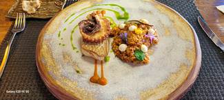 Sama con rejo de pulpo a la brasa acompañado con arroz meloso de calamar, romesco, alioli suave y aceite de perejil