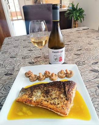 Con un salmón canadiense al eneldo sobre salsa de granadilla y champiñones