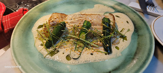 Filete de raya con salsa meunière, calabacin, quinoa crujiente, berberechos y hojas de ostra.