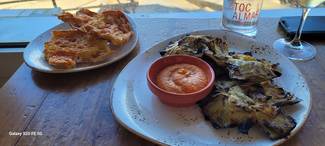 Alcachofas a la brasa con romesco y coca de cristal con tomate de colgar y AOVE