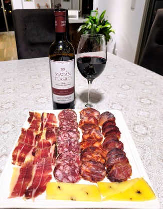 Con un surtido de queso de oveja trufado, embutidos y jamón ibéricos.
