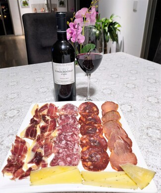 Con el surtido de queso de oveja trufado, embutidos y jamón ibéricos.