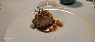 Berenjena a la brasa lacada con miel, con yogur ahumado, avellanas y hierbas aromáticas