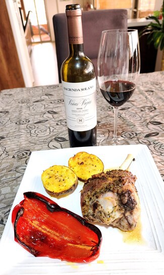 Con un muslo de pavo al horno con papas y pimiento rojo.