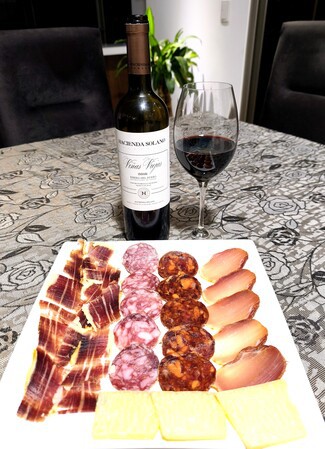 Con un surtido de queso parmesano, embutidos y jamón ibéricos