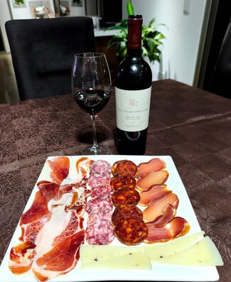 Con un rico surtido de queso de oveja trufado, embutidos y jamón ibéricos