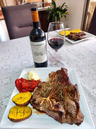 Con un Porterhouse al romero con papas, pimientos y all-i-oli