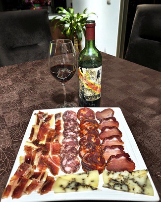 Con nuestro surtido de queso de oveja trufado, embutidos y jamón ibéricos.